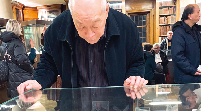 A man looks at a display case at a Living Knowledge Network event]