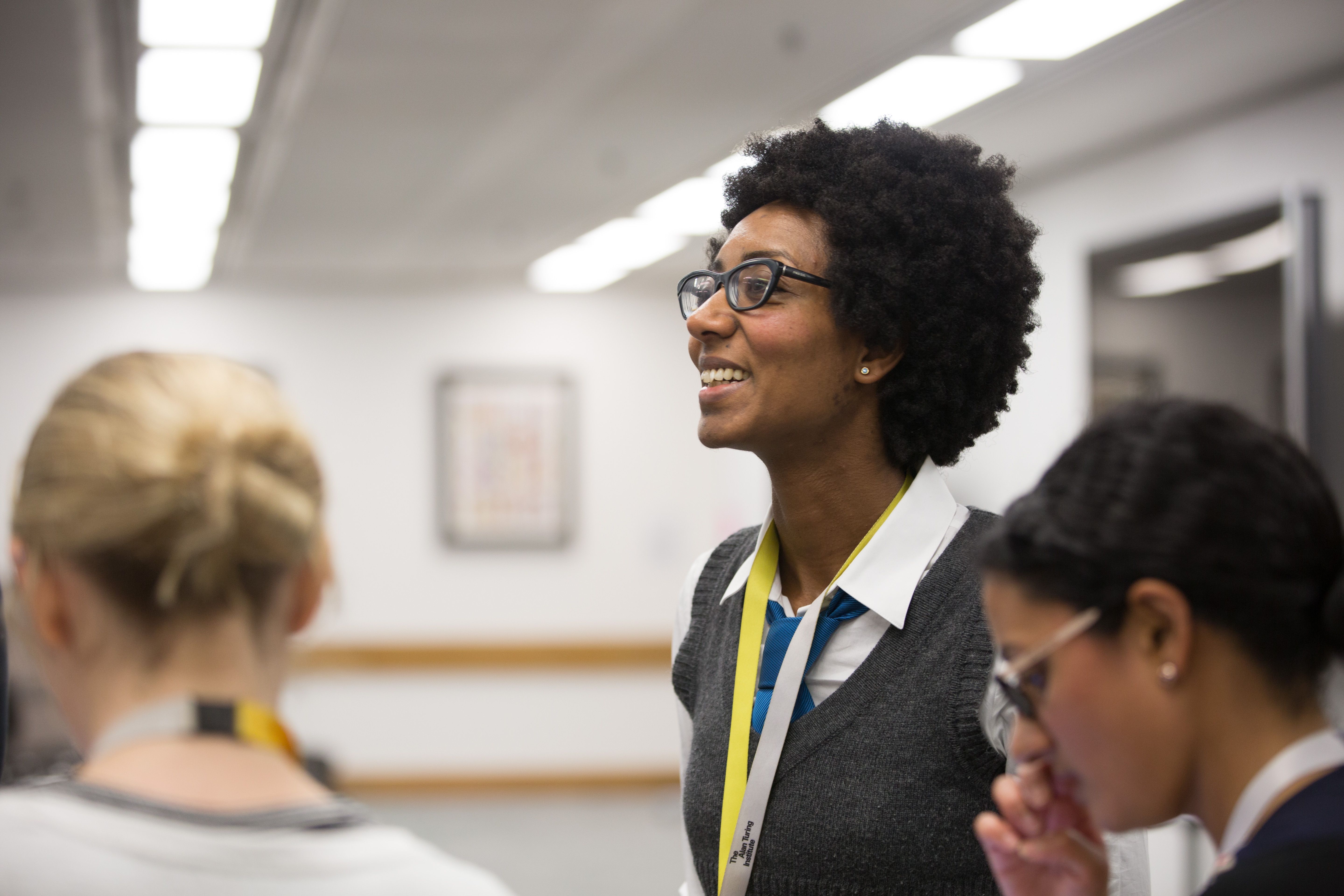 Three people stand together at a British Library networking event.