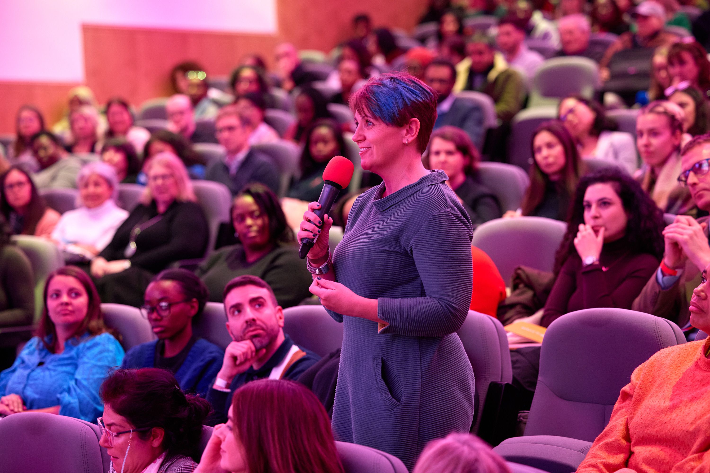 Woman with microphone in audience.