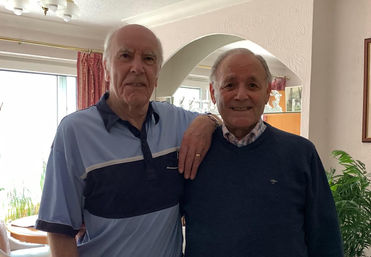David Swann and Derek Woolf smile as they stand side-by-side.