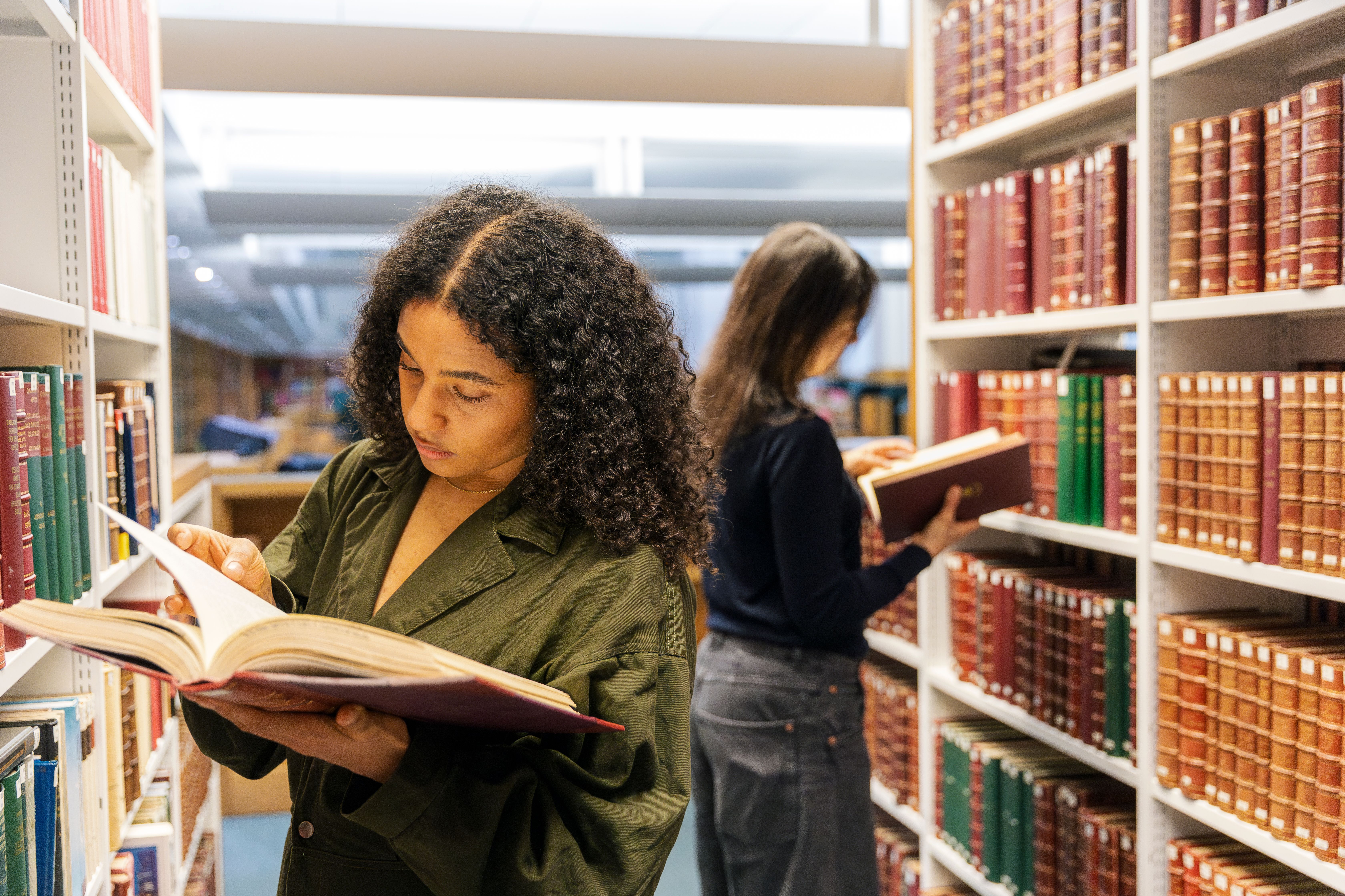 People using collection items held on the open shelves in a British Library Reading Room