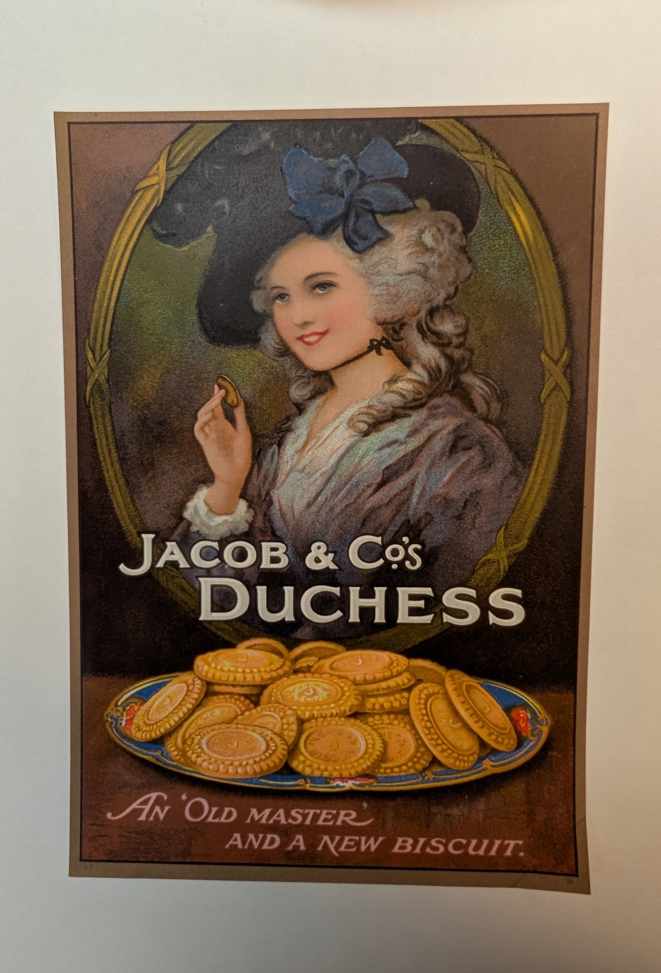An advert for biscuits, showing a woman with a large hat and formal clothes eating a biscuit.  Author: W. & R. Jacob & Co., Title: [Jacob & Co's Biscuits], year: [1924].