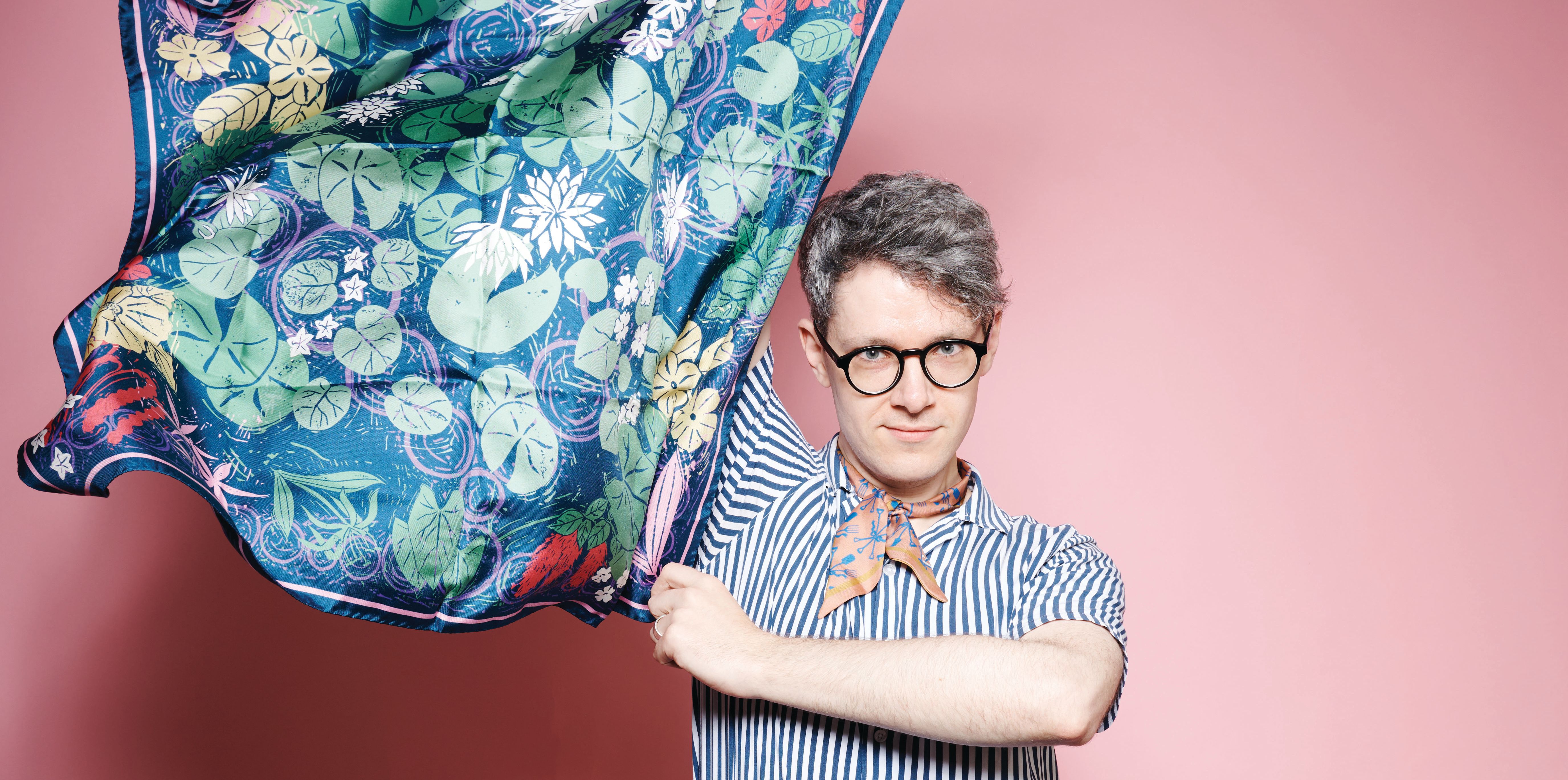 A business man holds a silk scarf.