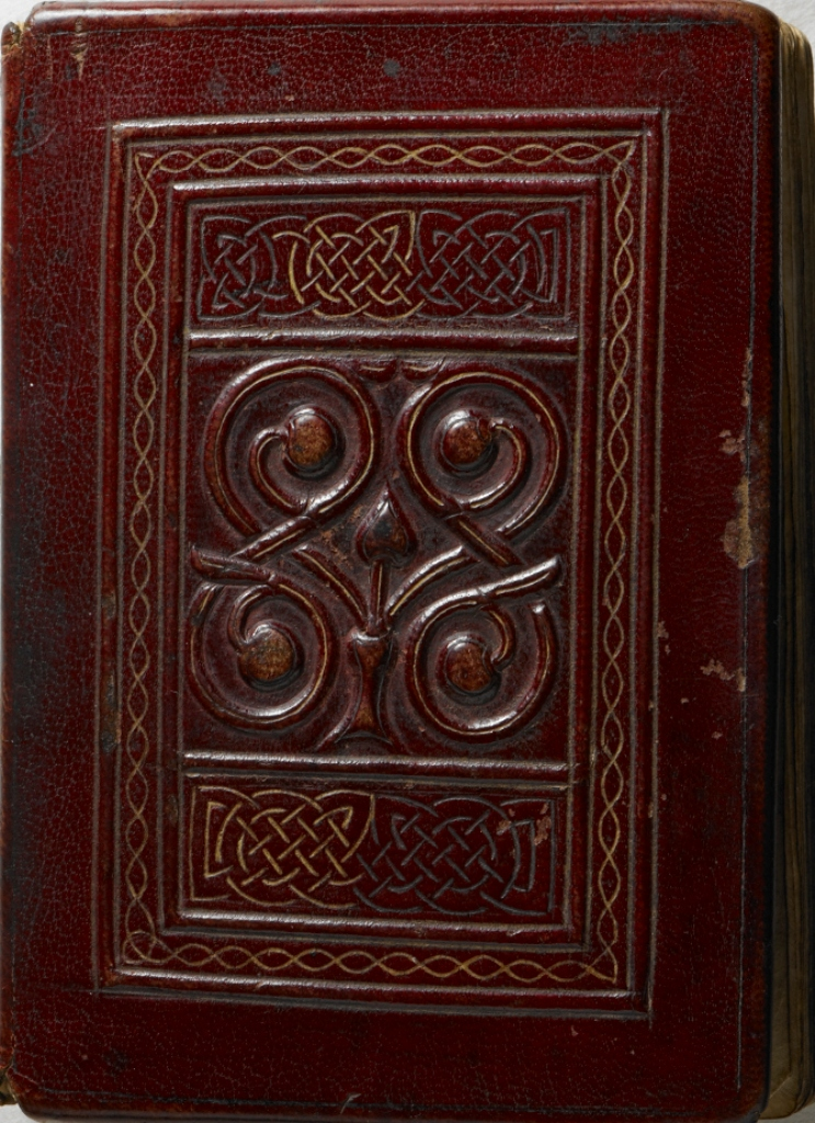 The front cover of the St Cuthbert Gospel, covered in leather dyed a deep crimson, and with a central motif containing a chalice from which stems project, terminating in a leaf or bud and four fruits (London, British Library, MS Additional 89000).