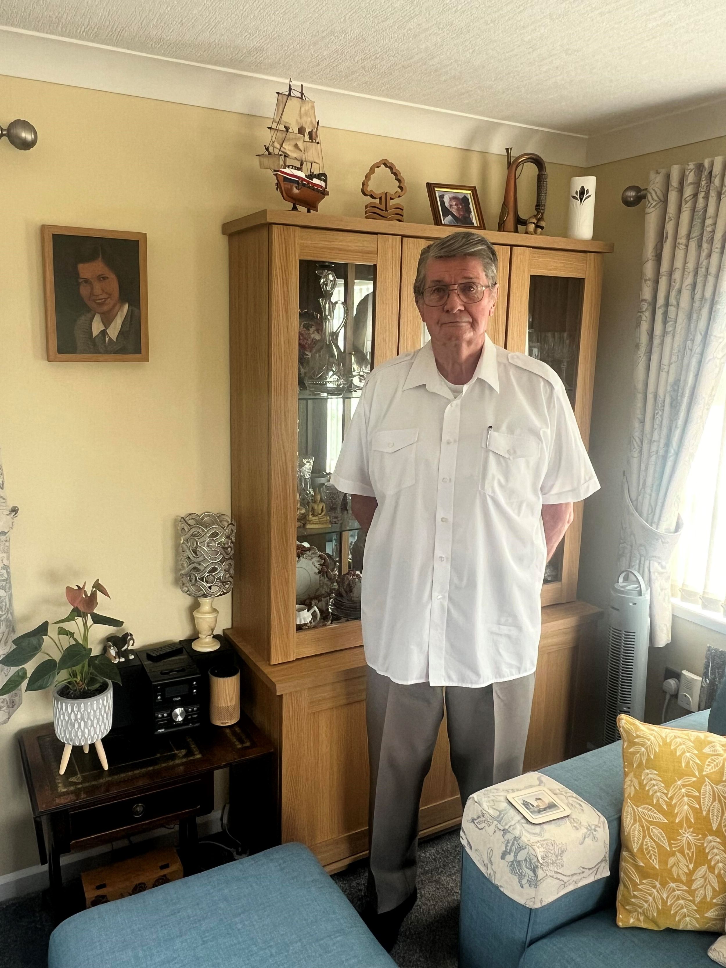 Neil Rose stands next to the portrait of his mother at his home near Tewkesbury, Worcestershire.