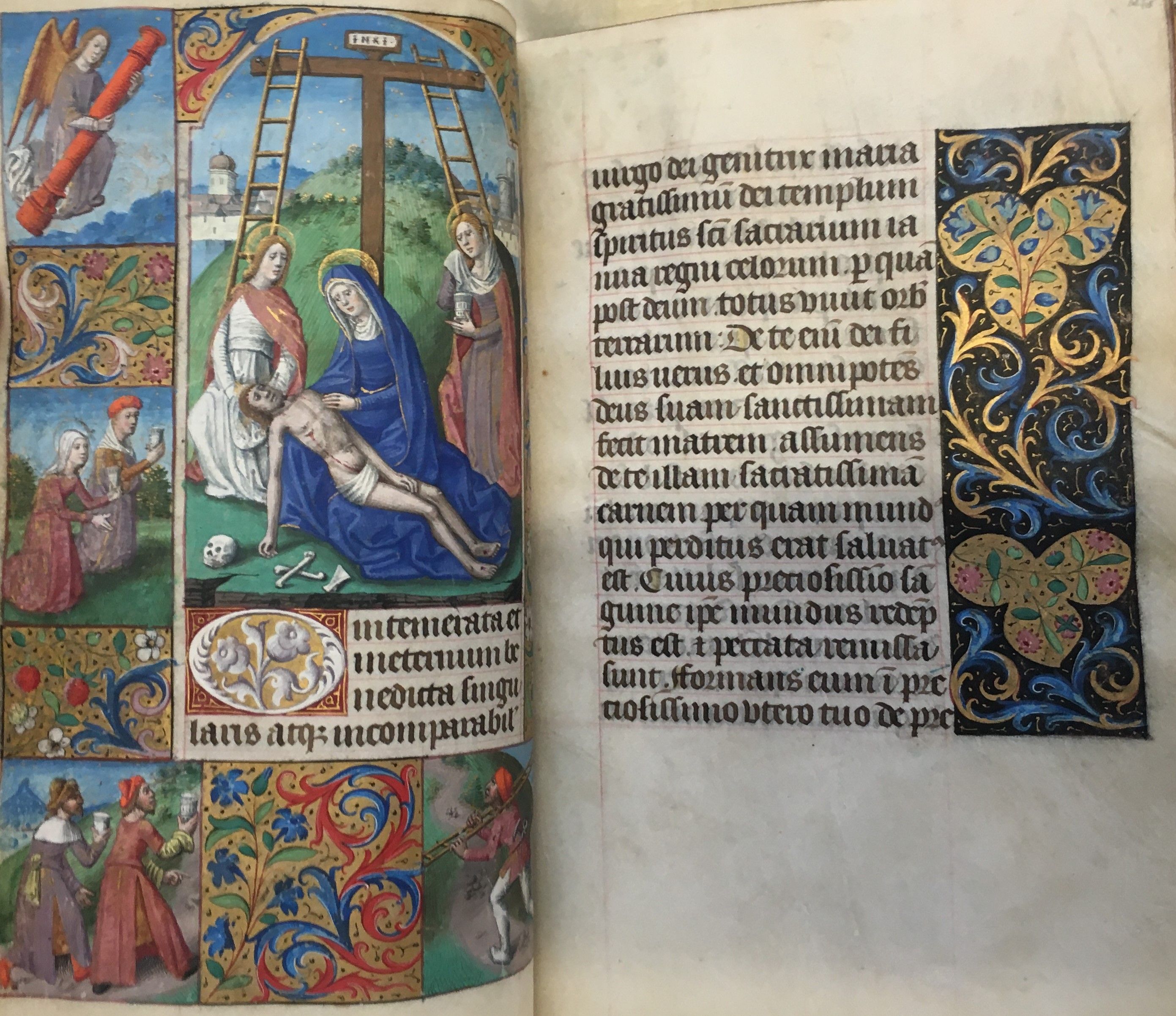An opening from a medieval Book of Hours, showing a full-page illustration of the Deposition from the Cross, with foliate borders in colours and gold.