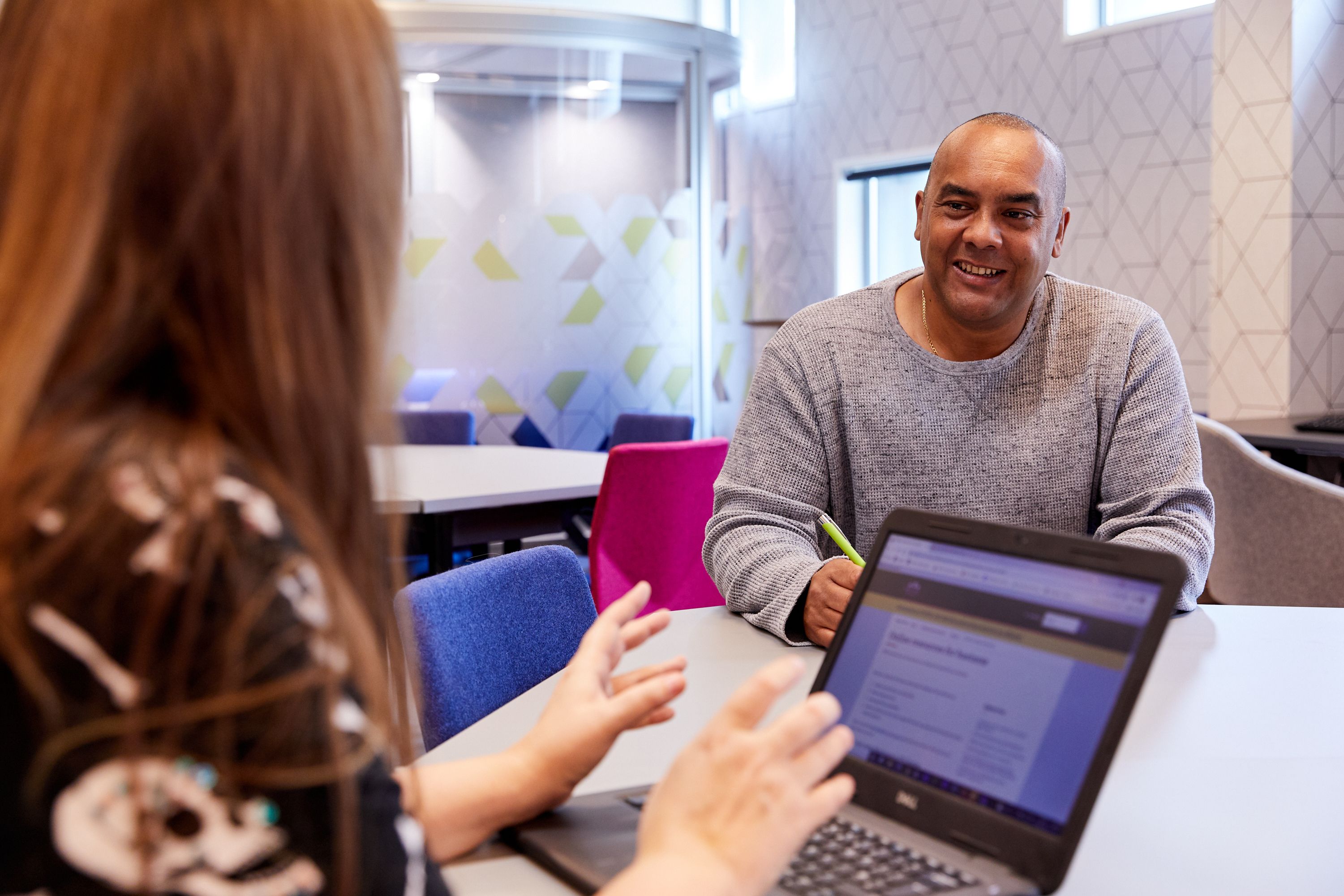 A man and a woman talk at a business centre (BIPC) in Brighton Library.