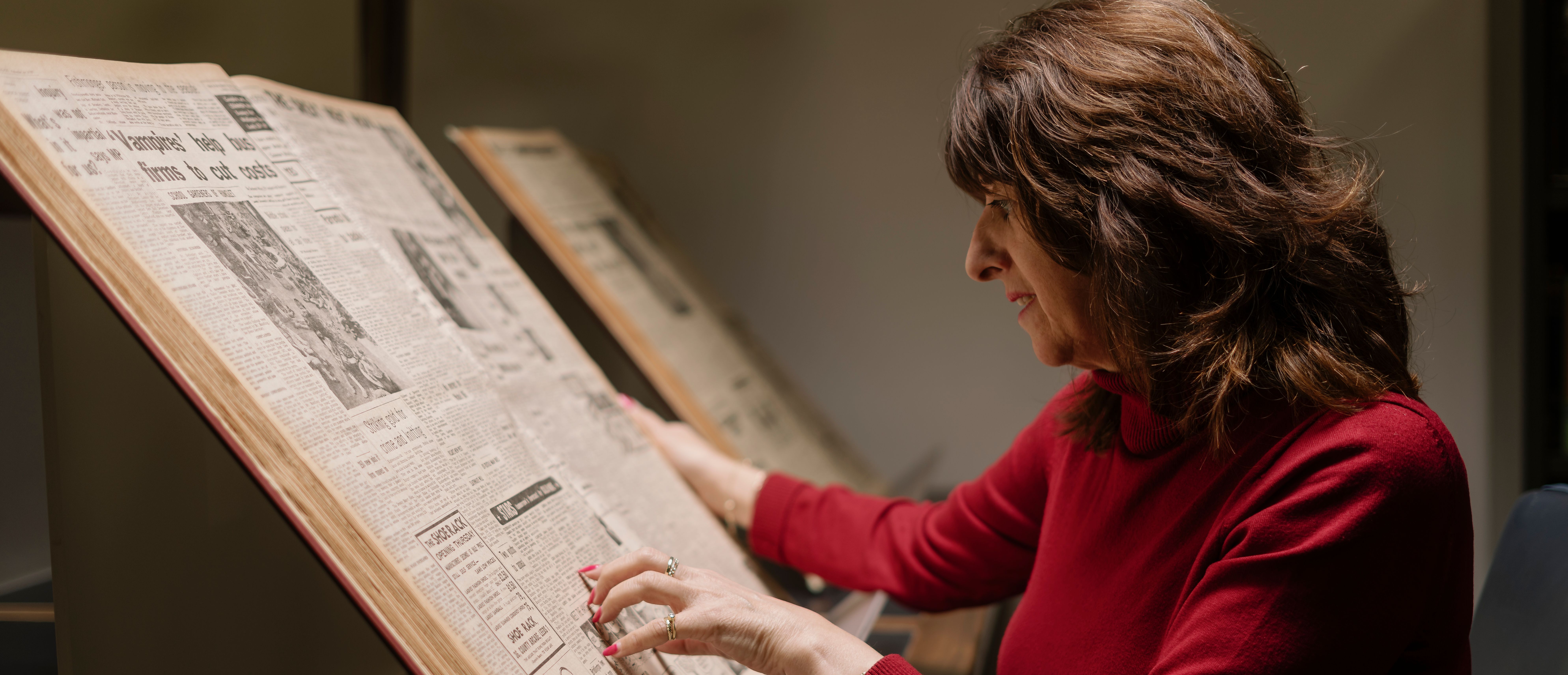 A woman reads a newspaper from the British Library collections, in a Reading Room in Boston Spa, West Yorkshire.
