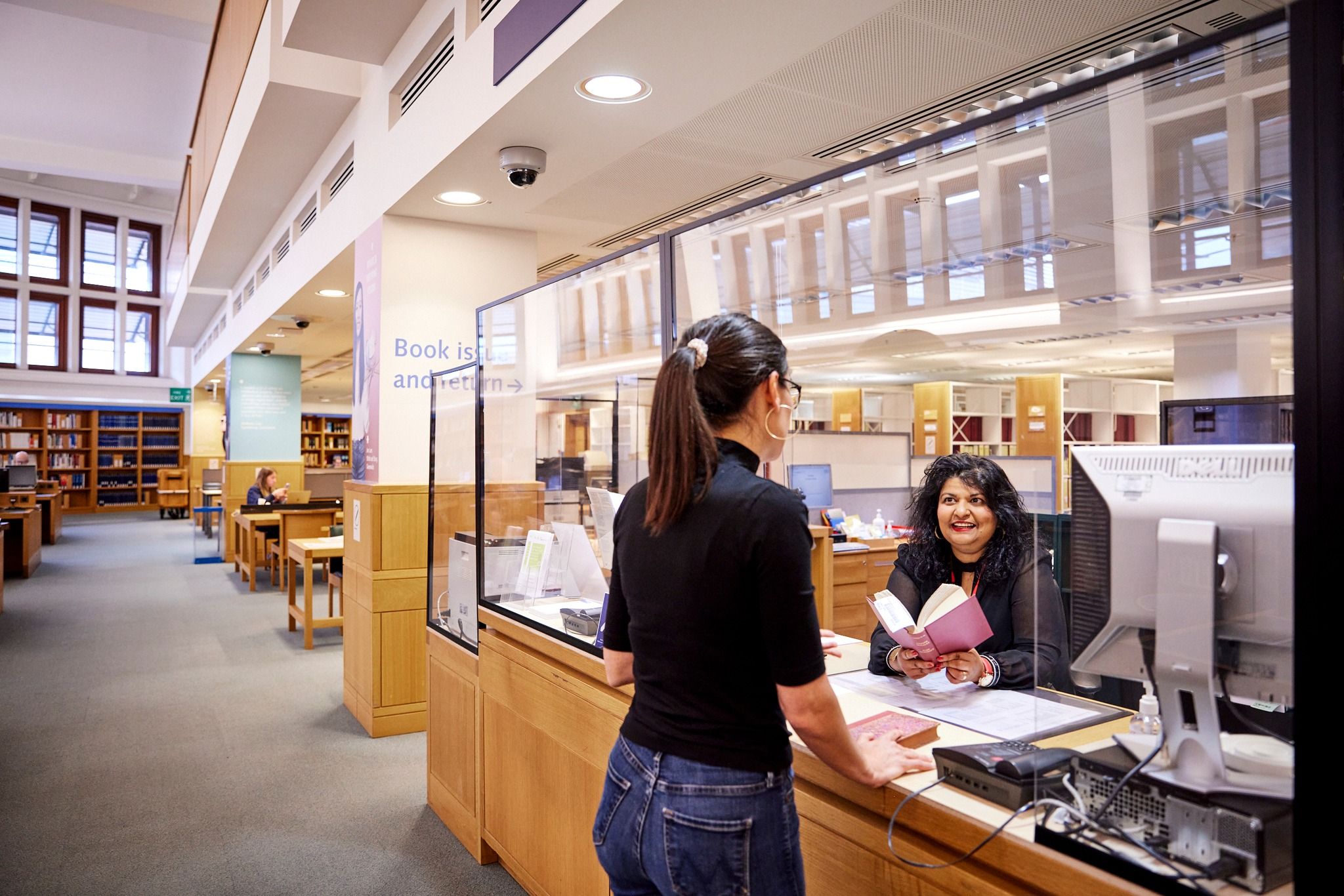 Library visitor at book issue desk.