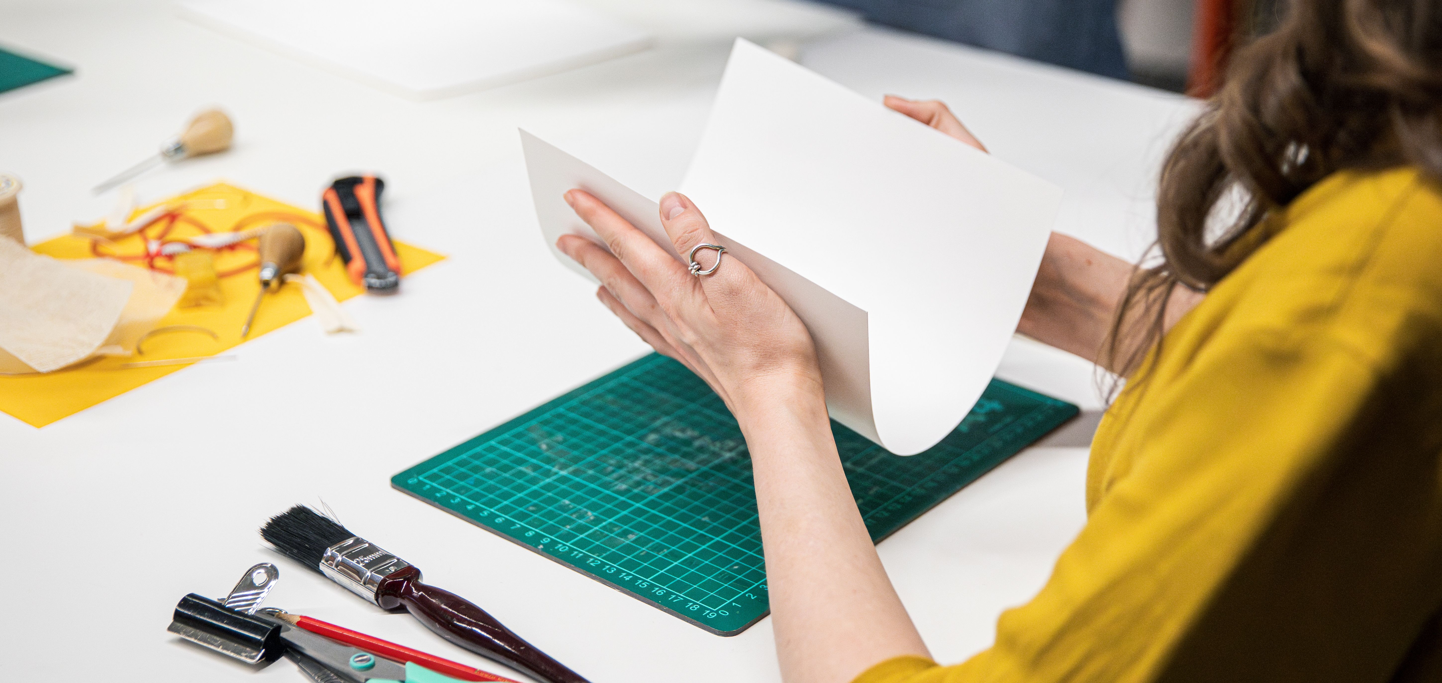 A woman carefully folds paper at an adult learning course at the British Library.