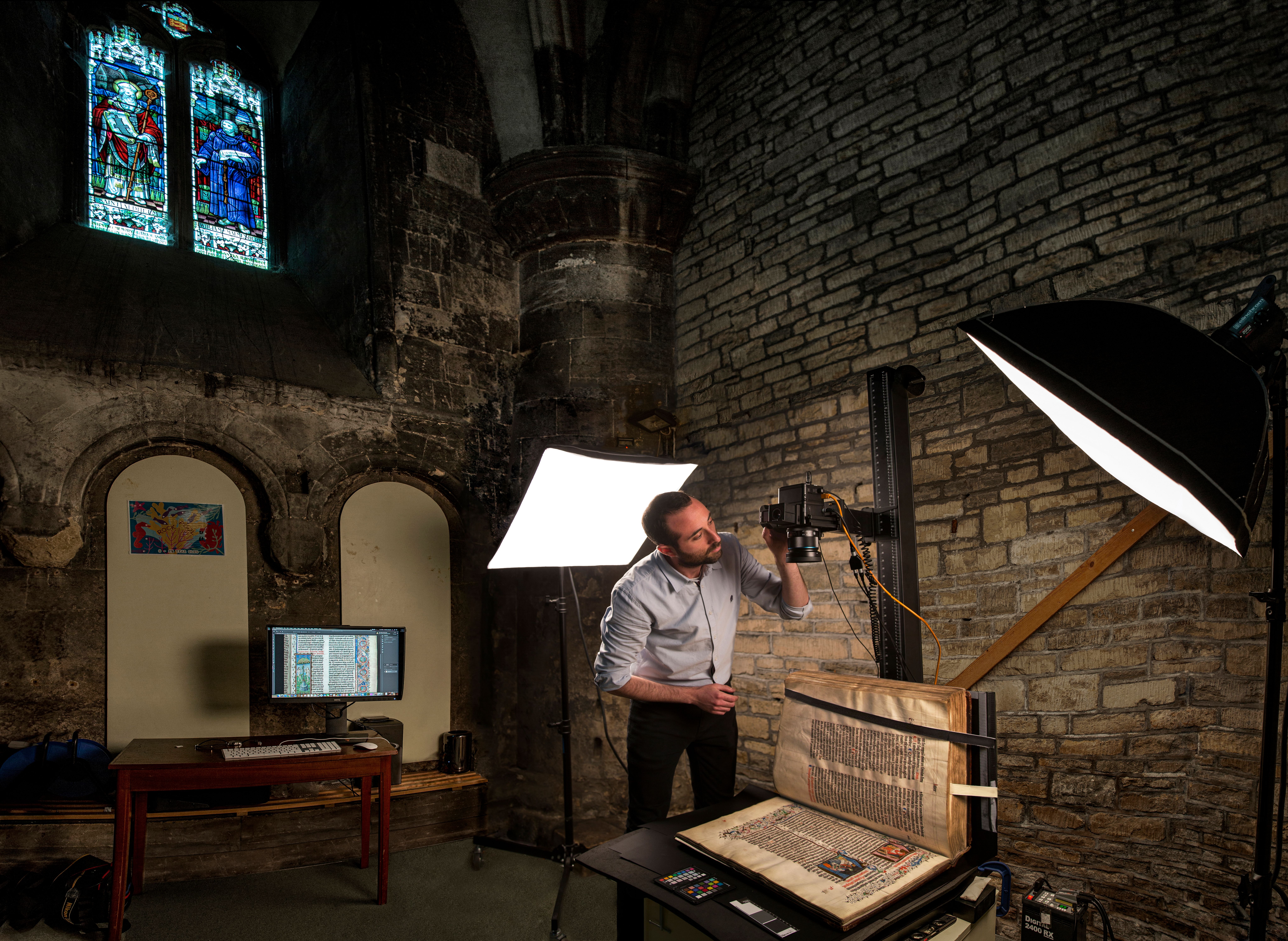 Photographer with Malmesbury Bible and photography equipment.