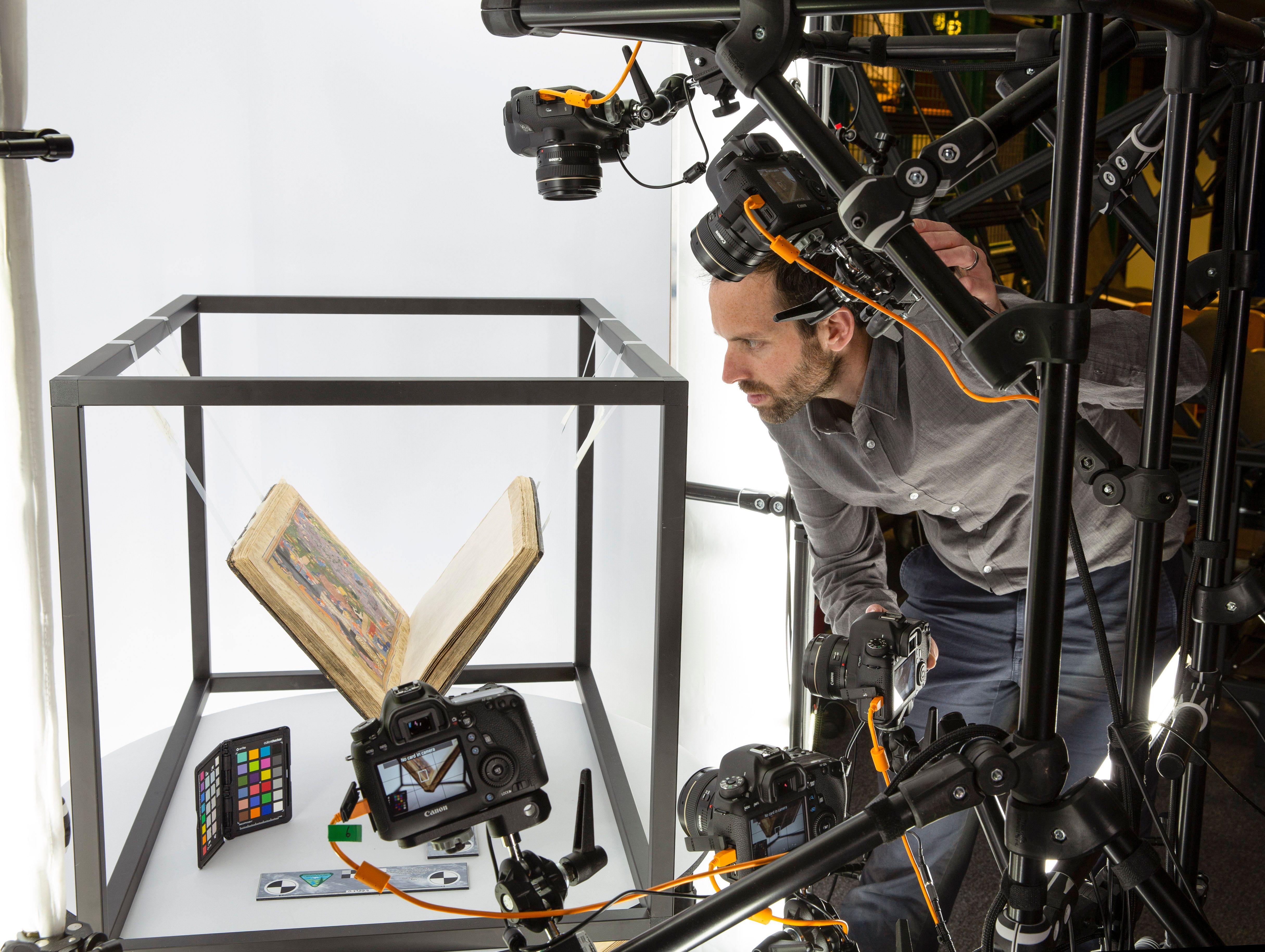 Man with multiple cameras digitising a collection item.