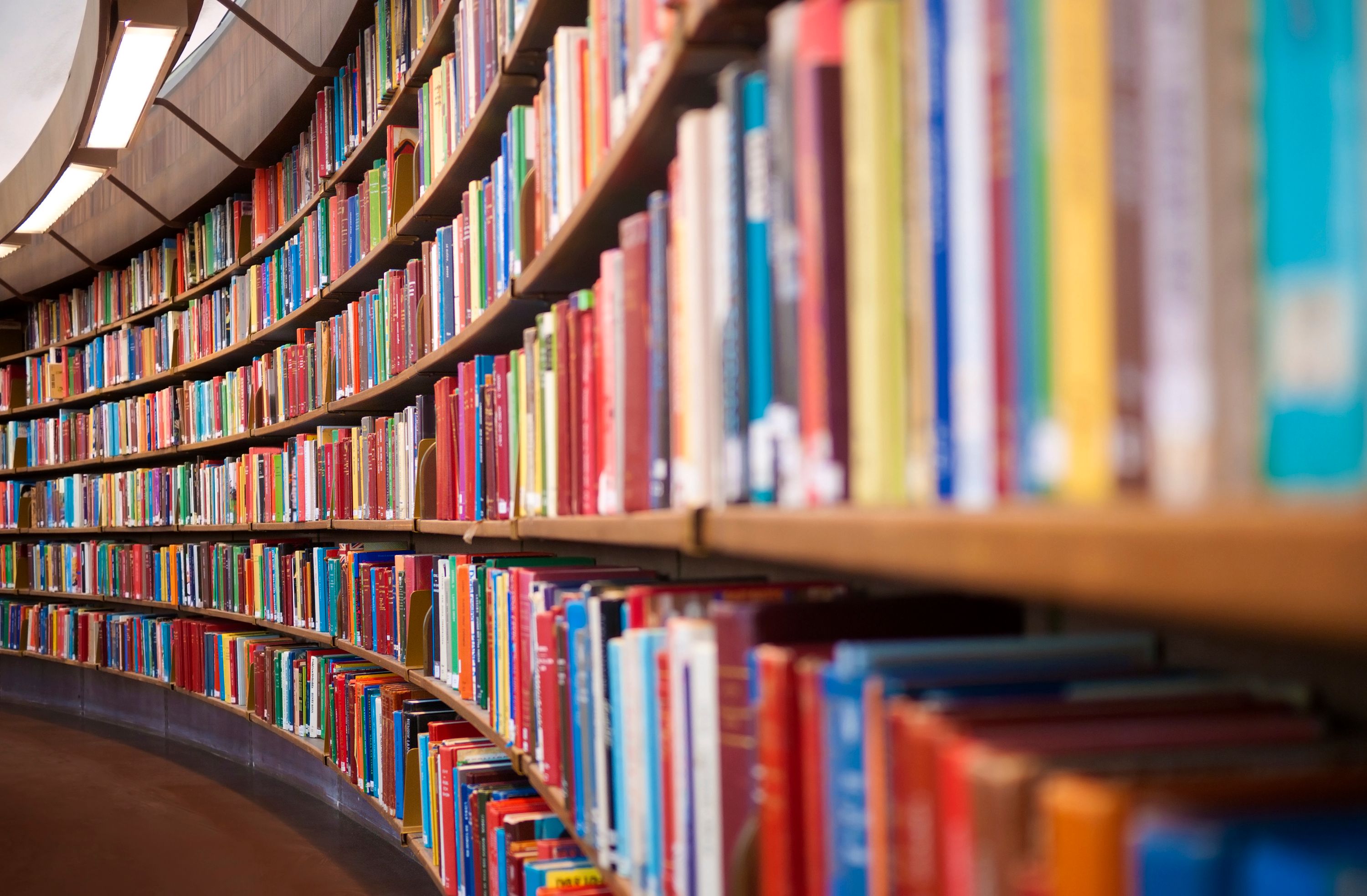 Library books on curved shelves.