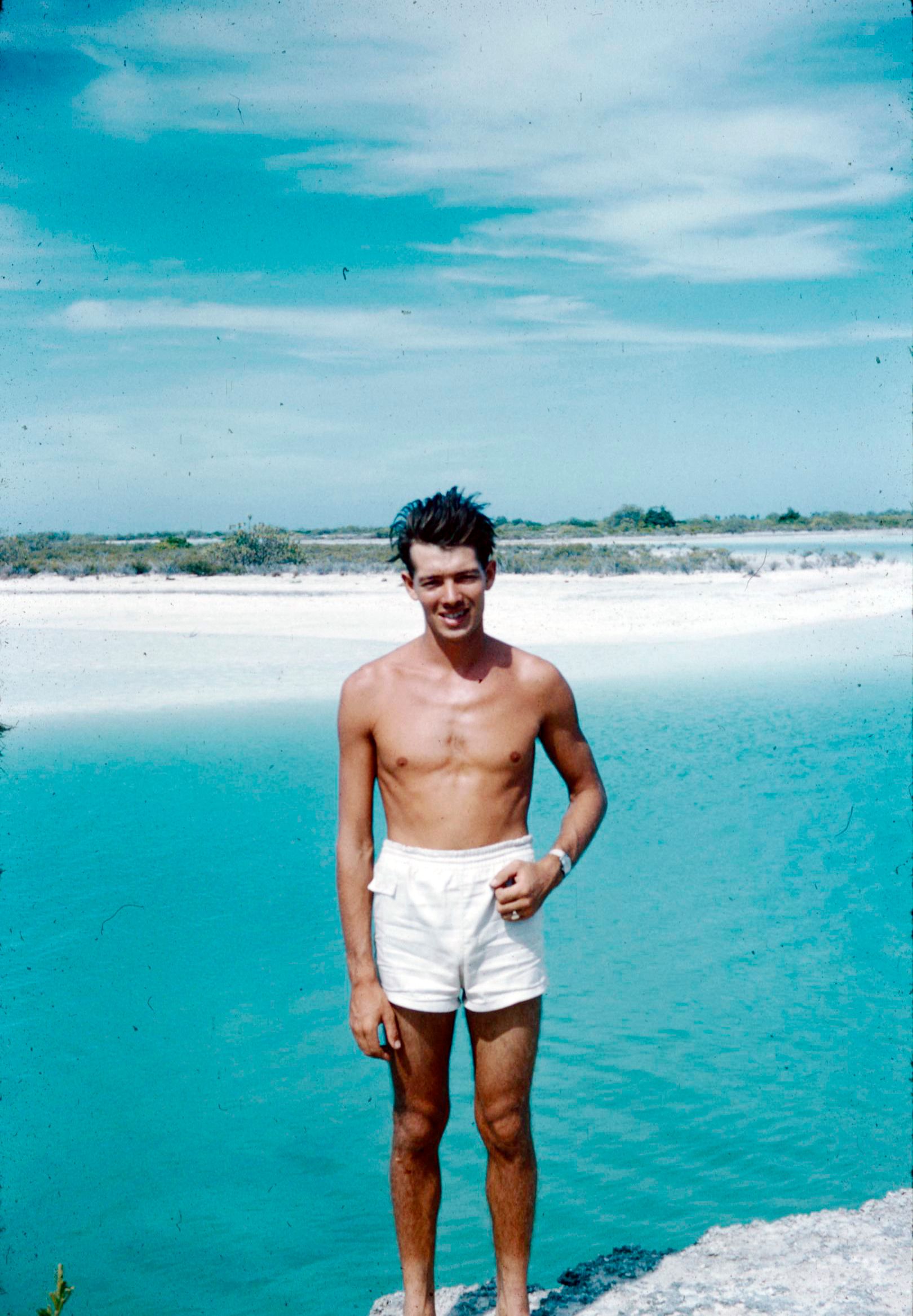 Frank Bools stands in a lagoon in white shorts on Christmas Island.