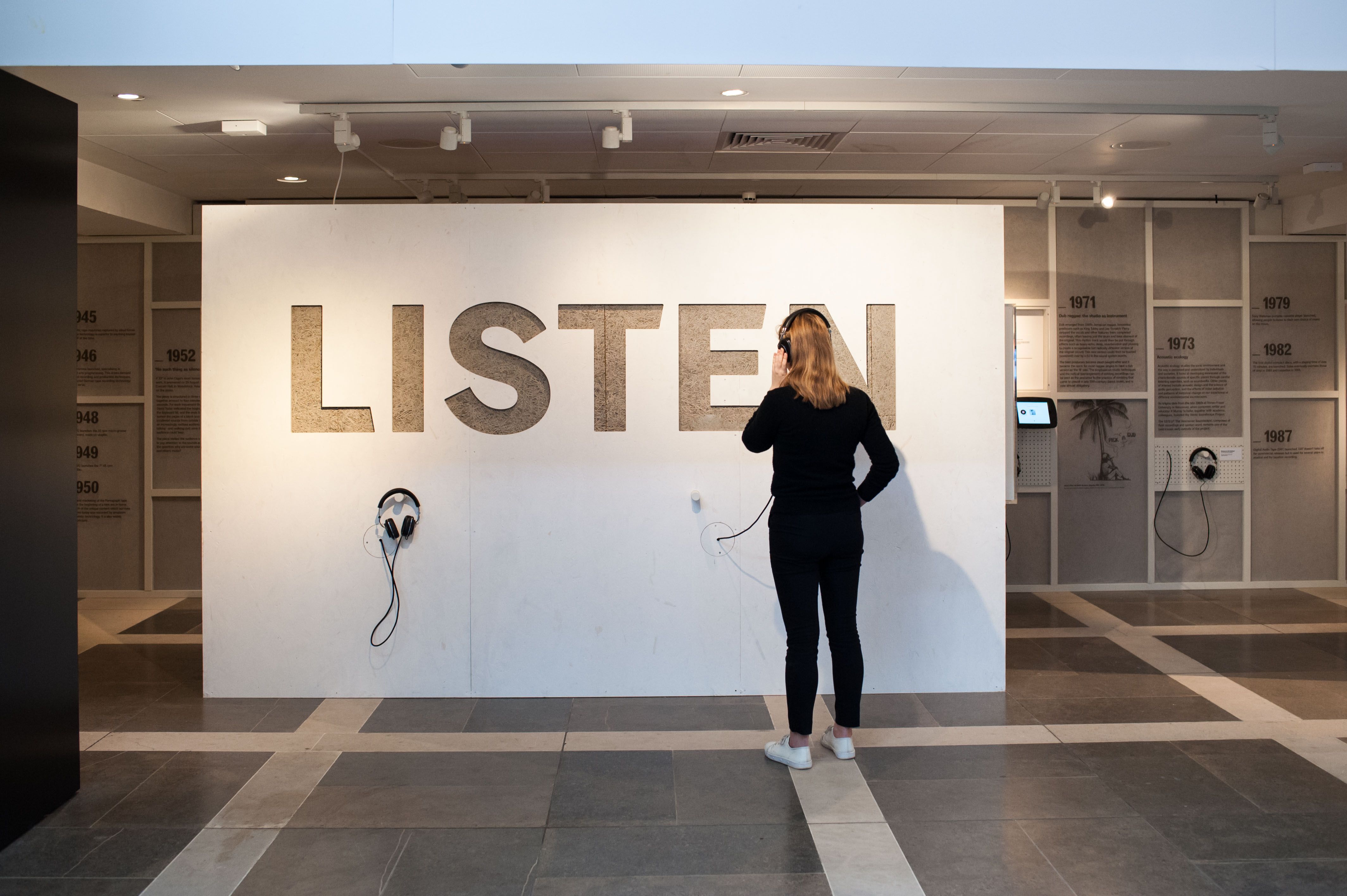 A woman listening to material in the Listen exhibition at the British Library 2017-2018.