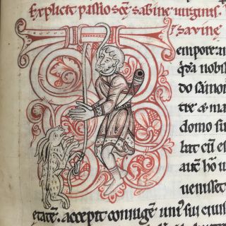 Decorated letter T from a manuscript. Two rabbits are hanging a human hunter from the top of the letter T. The hunter has a hunting horn slung over his shoulder