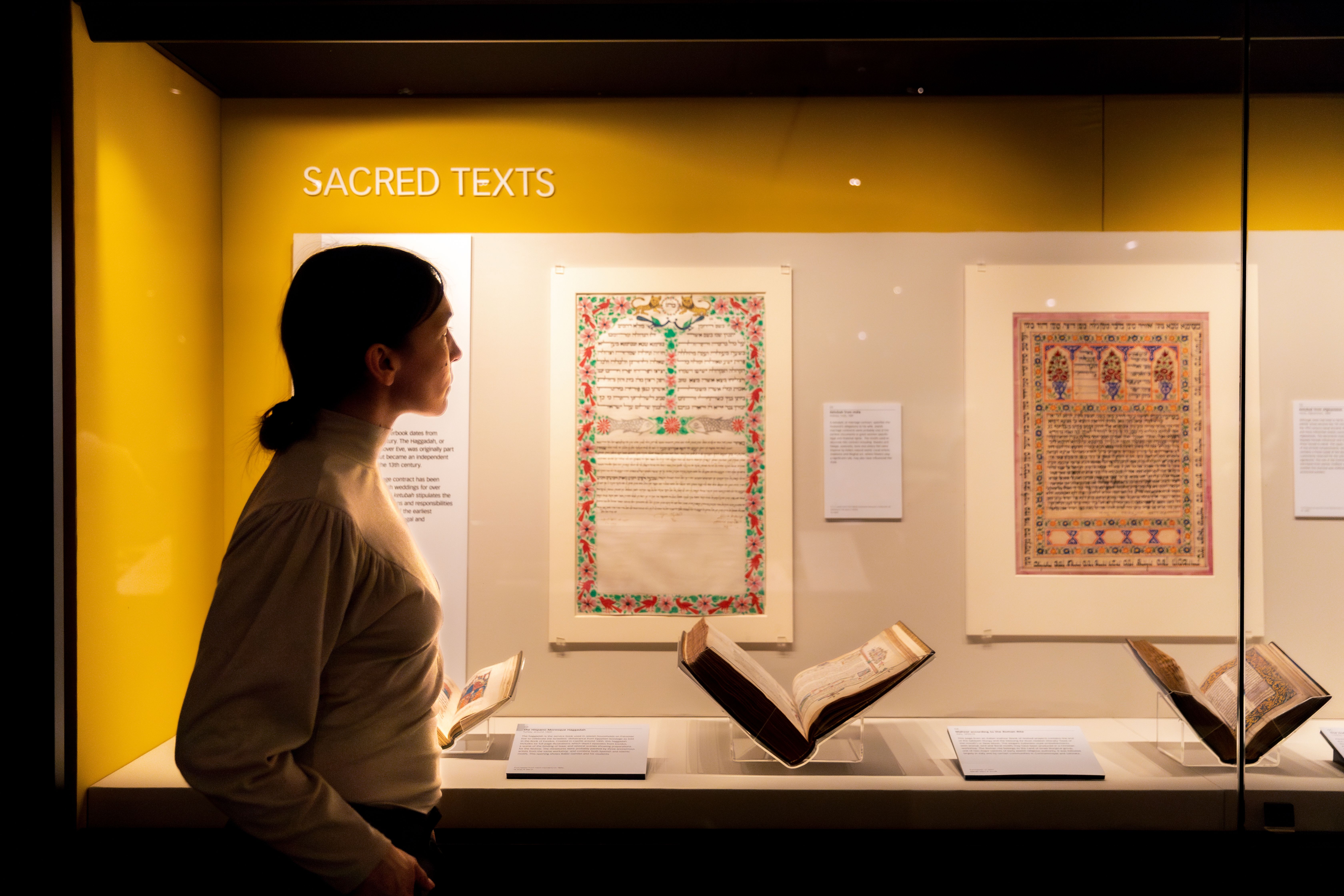 Person looking at Sacred Texts in the British Library's Treasures Gallery
