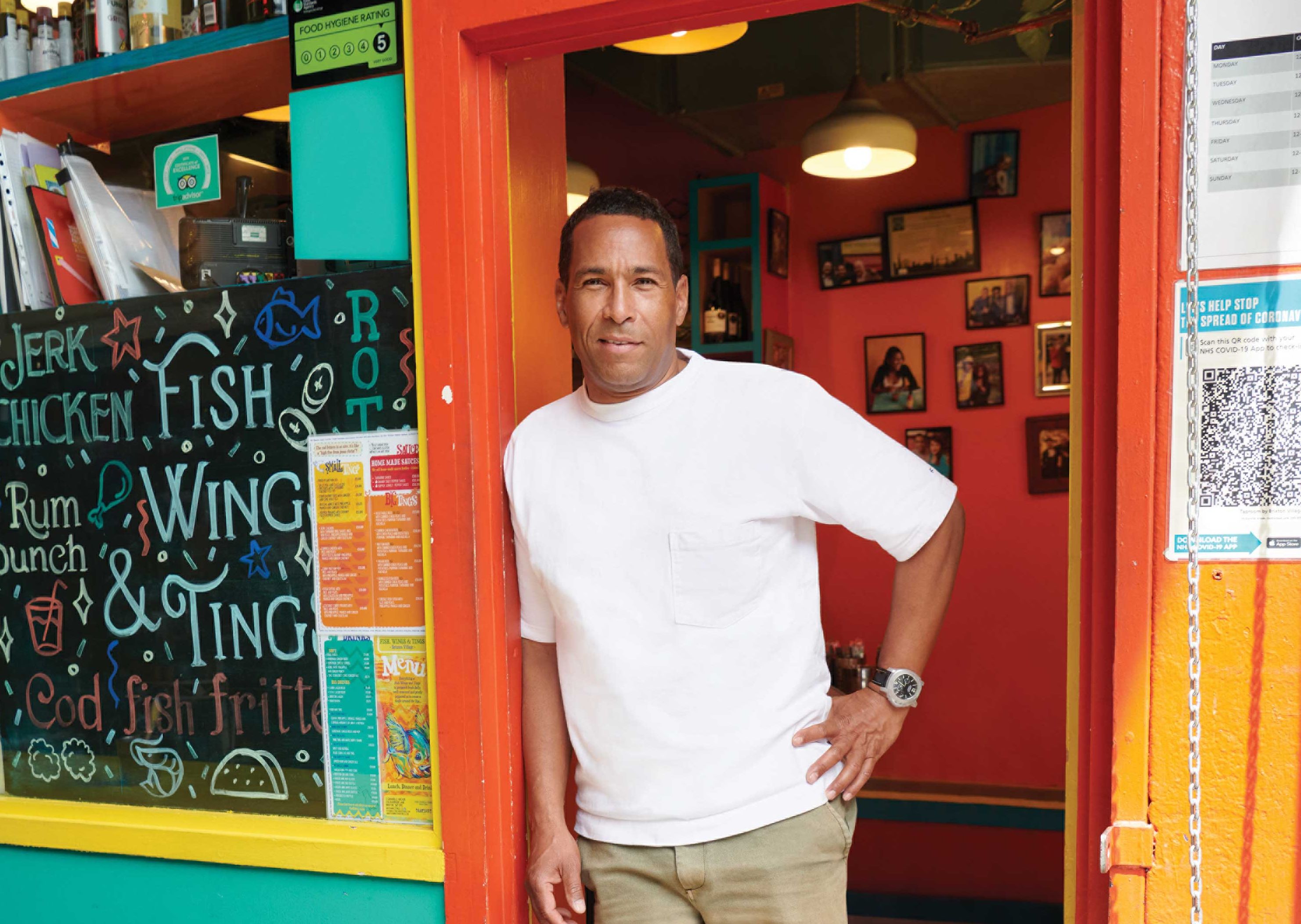 A business man stands in a cafe doorway.