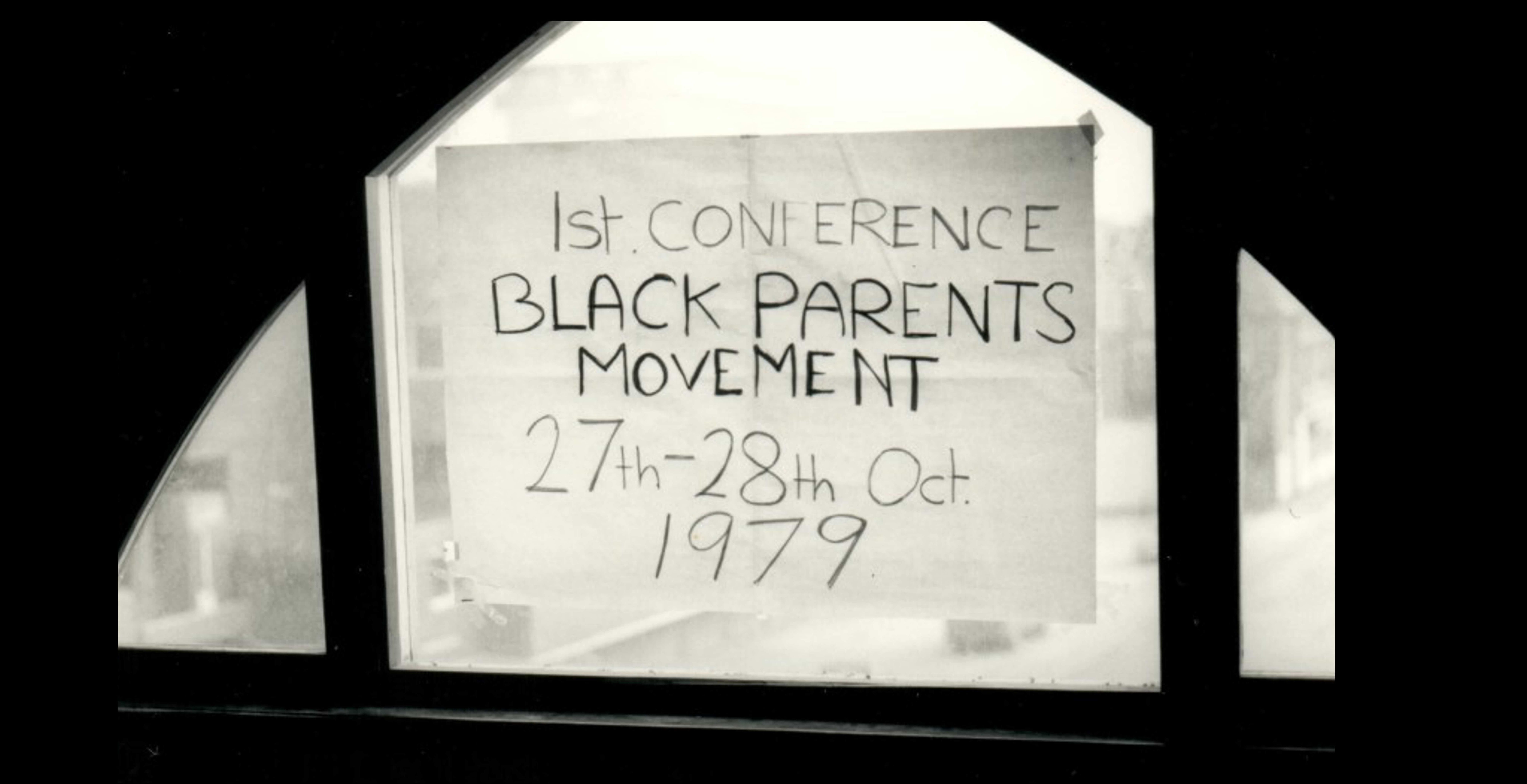 A sign on a window saying 1st Conference: Black Parents Movement