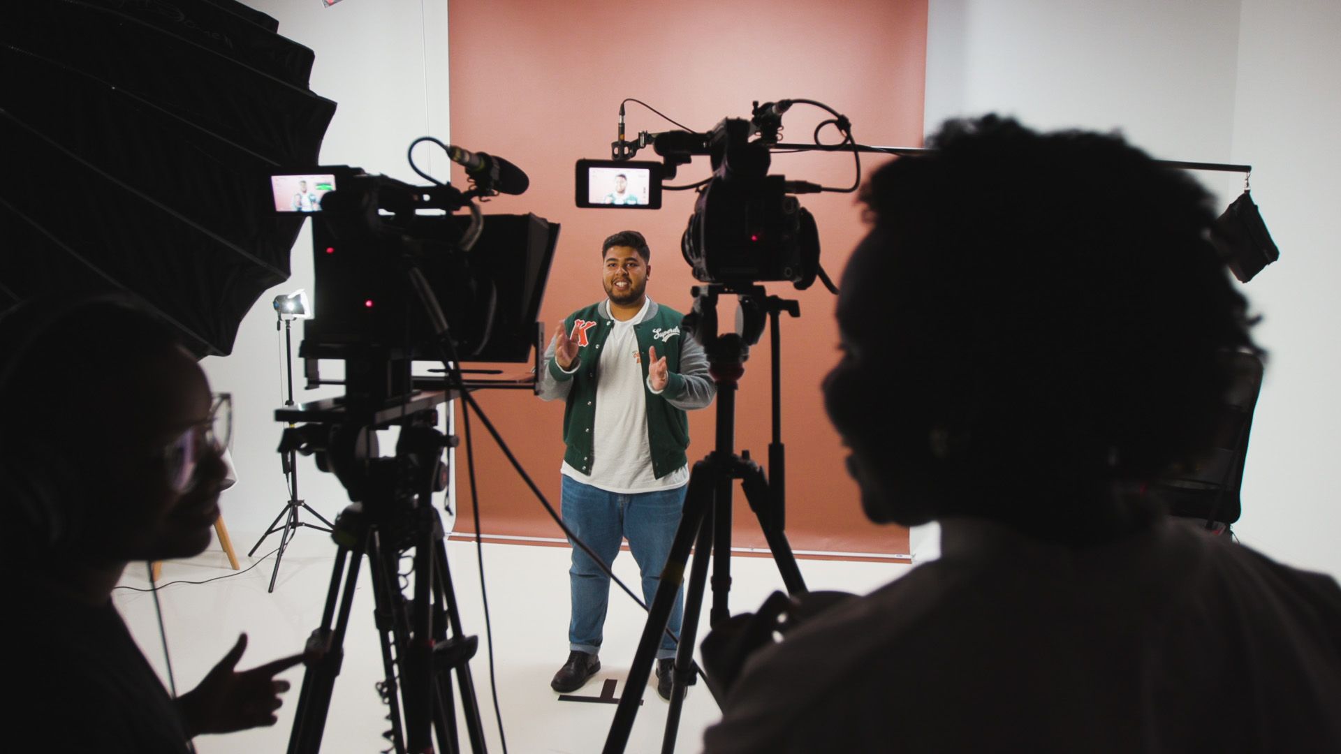 Man speaking in front of video cameras.