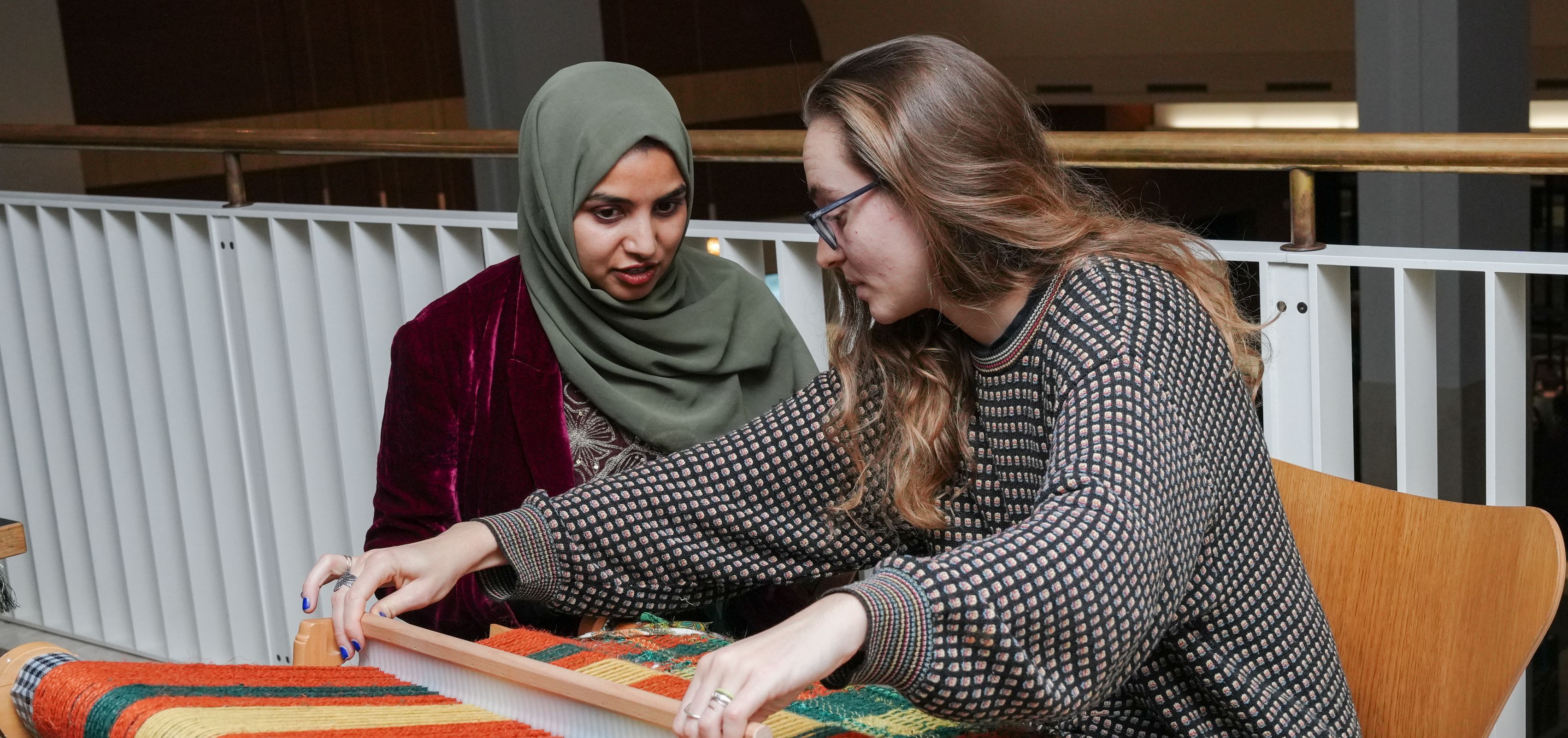 Two people making a tapestry inside the British Library