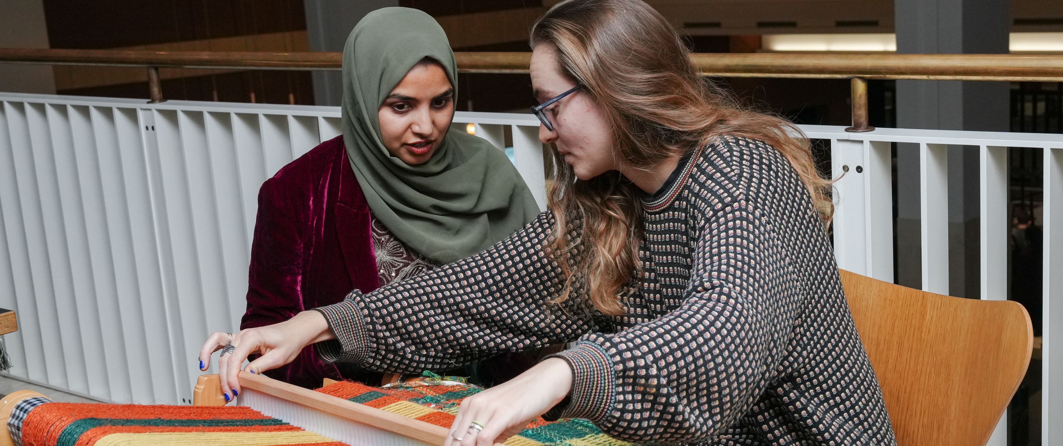 Two people making a tapestry inside the British Library