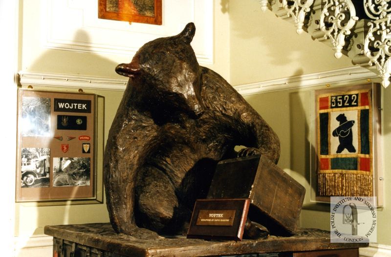 A statue of a bear looking into a box
