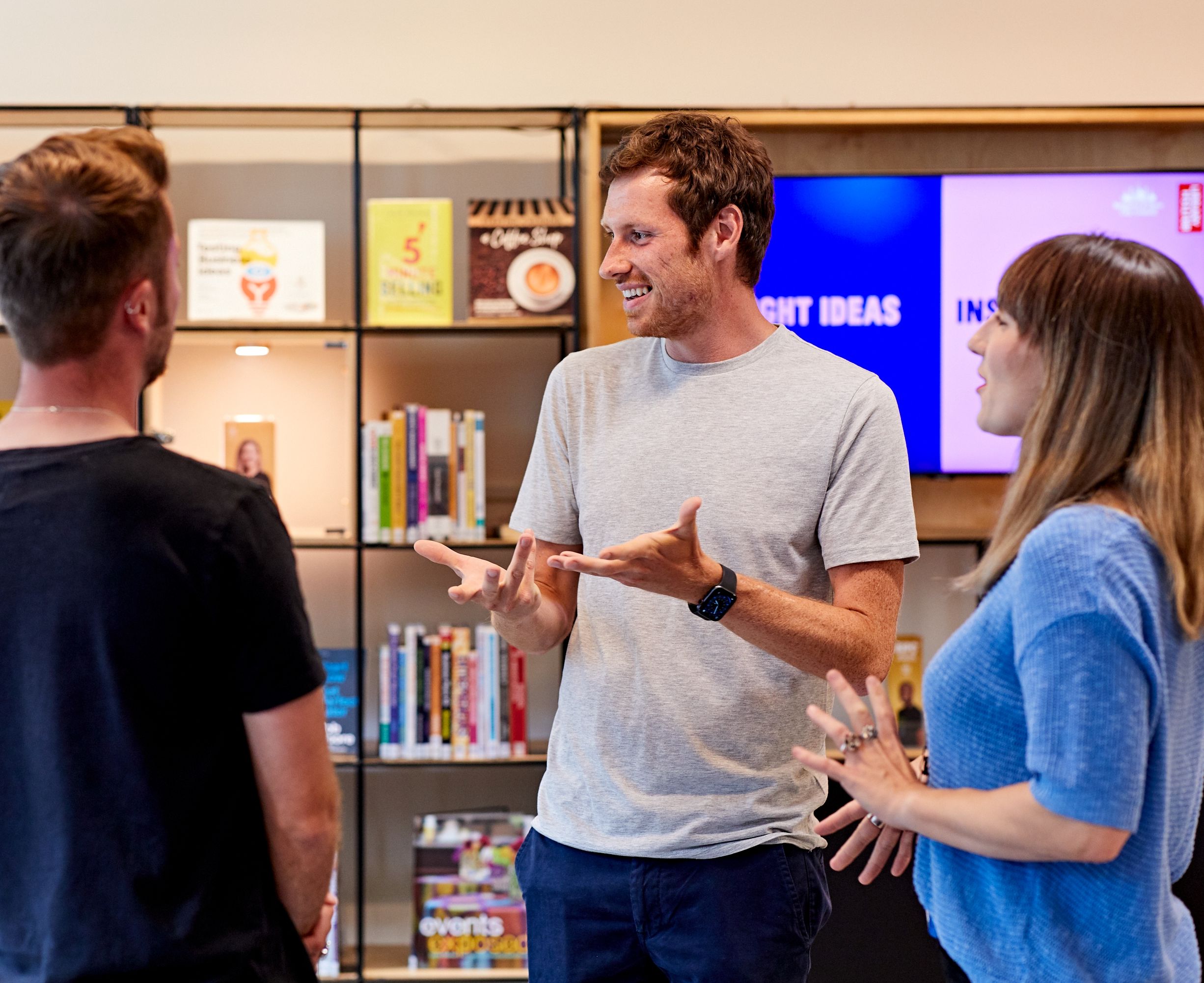 Four people standing and talking in a circle, in a business centre.