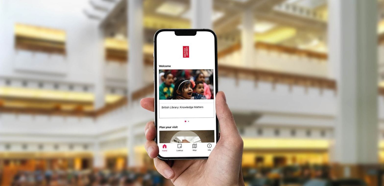 A hand holding up a phone displaying the Bloomberg Connects app in a Reading Room.
