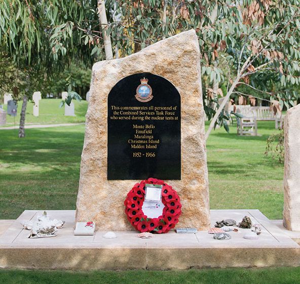 Three stone headstones stand in line to commemorate nuclear test veterans. They have black inserts, and text that recognises the different sites on which veterans served.