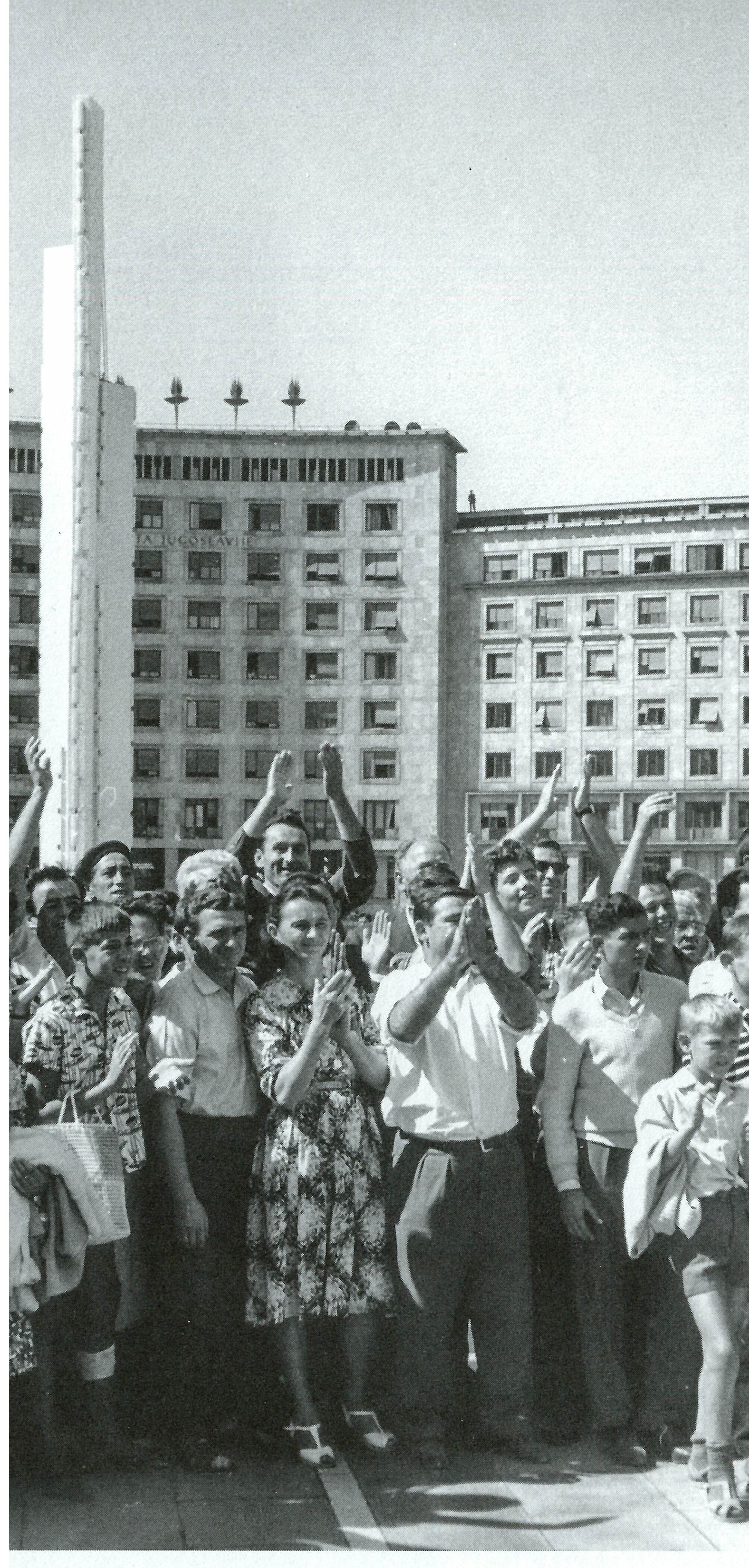People cheering in front of a Soviet building