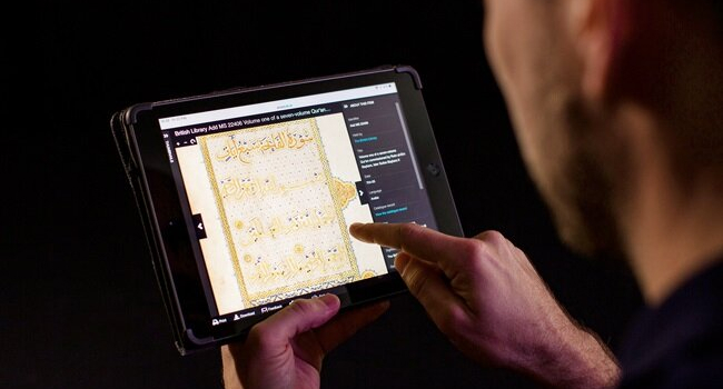 A man studies a manuscript on a tablet